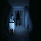 A dark hallway is barely illuminated by a flashlight, revealing a shadowy figure blocking the only exit.